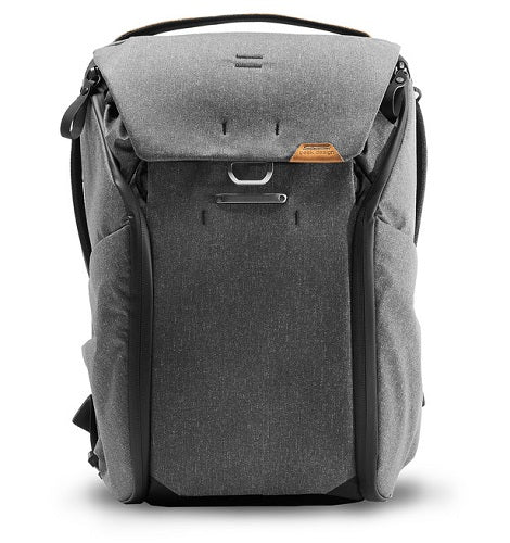A gray and black backpack with a textured fabric body, black trim, and a small orange brand patch on the front flap, shown against a plain white background.