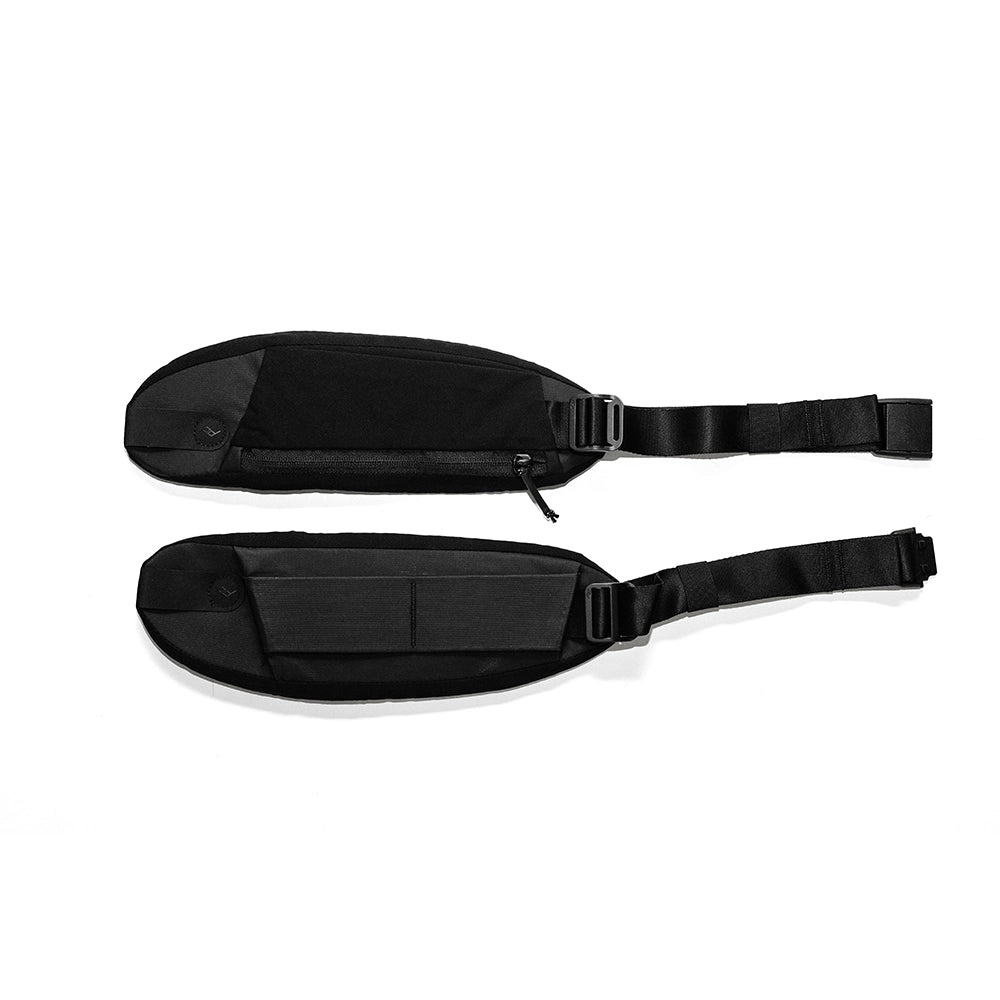 Two black parts of Peak Design hip belt on a white background
