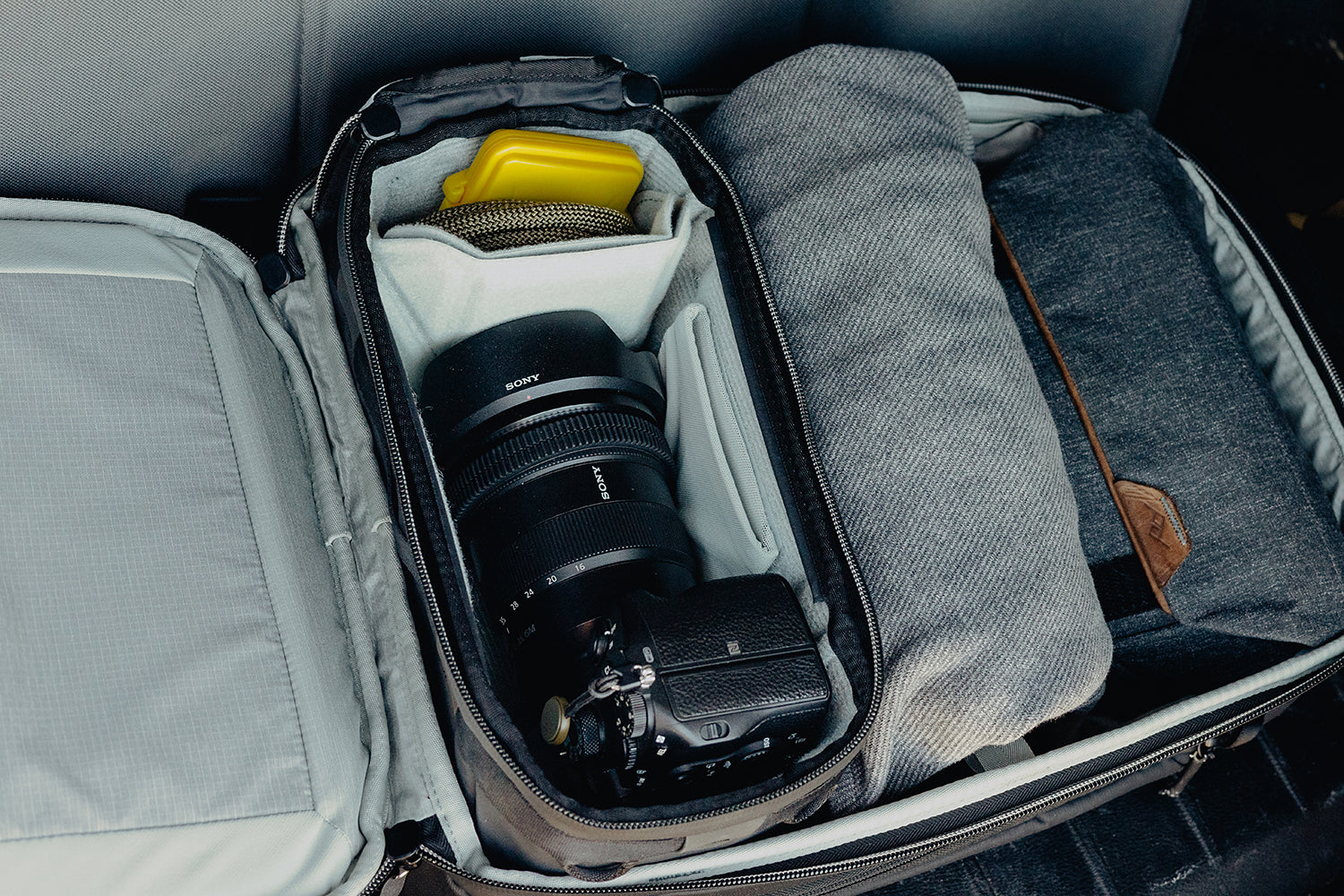 Camera and lens inside a gray travel bag