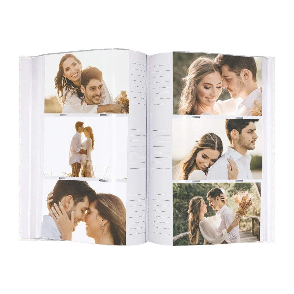 An open personalized photo album showing two spread pages filled with printed couple photographs on white pages, photographed against a plain white background.